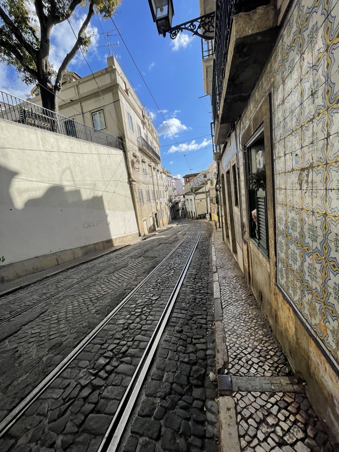 Lisbon street with tram tracks and tiled facade