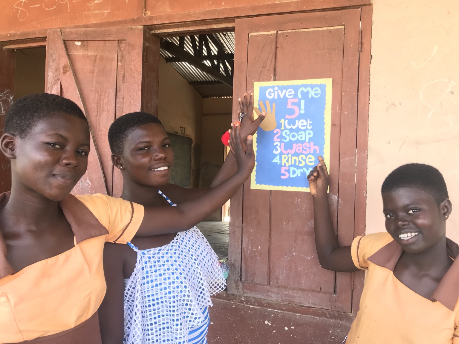 Schoolchildren beside a handwashing reminder